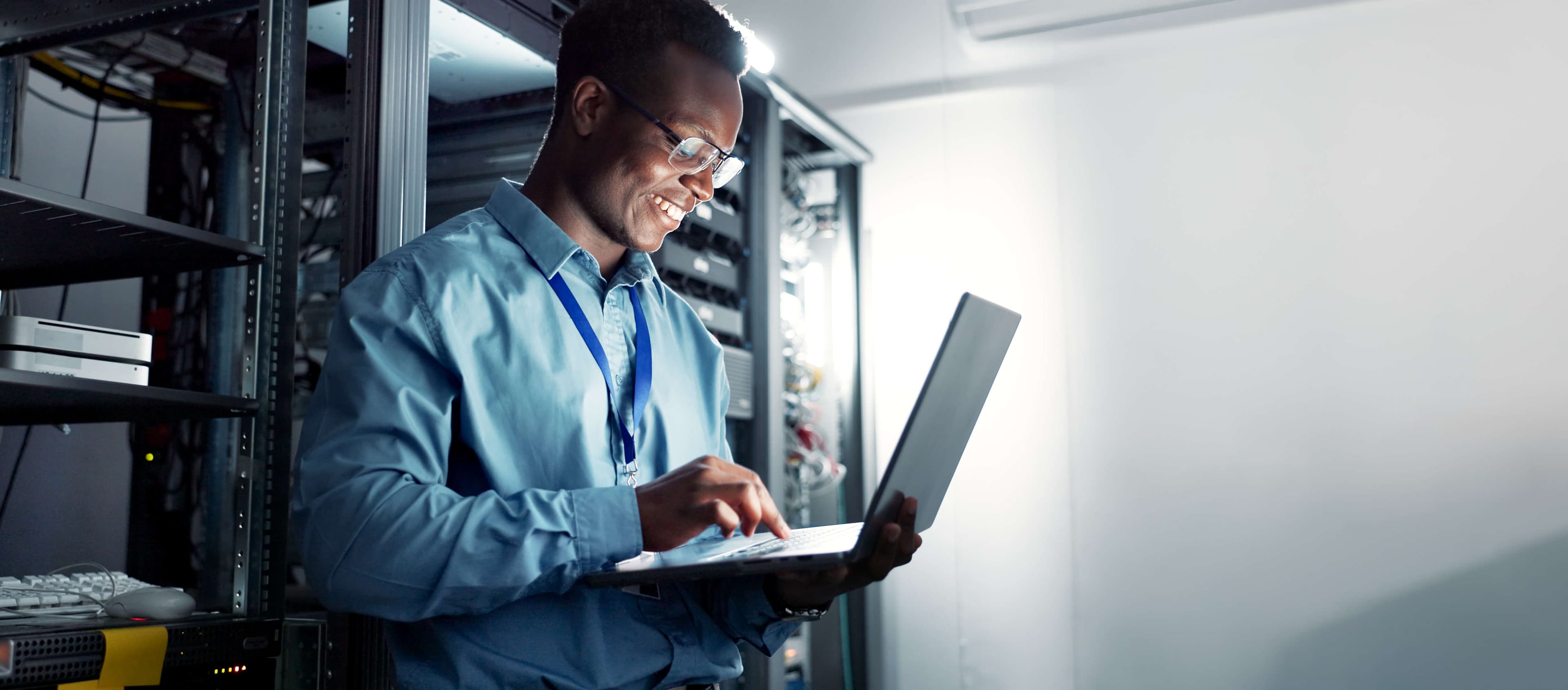 Black IT support engineer assisting a colleague at a workstation in a Lagos office